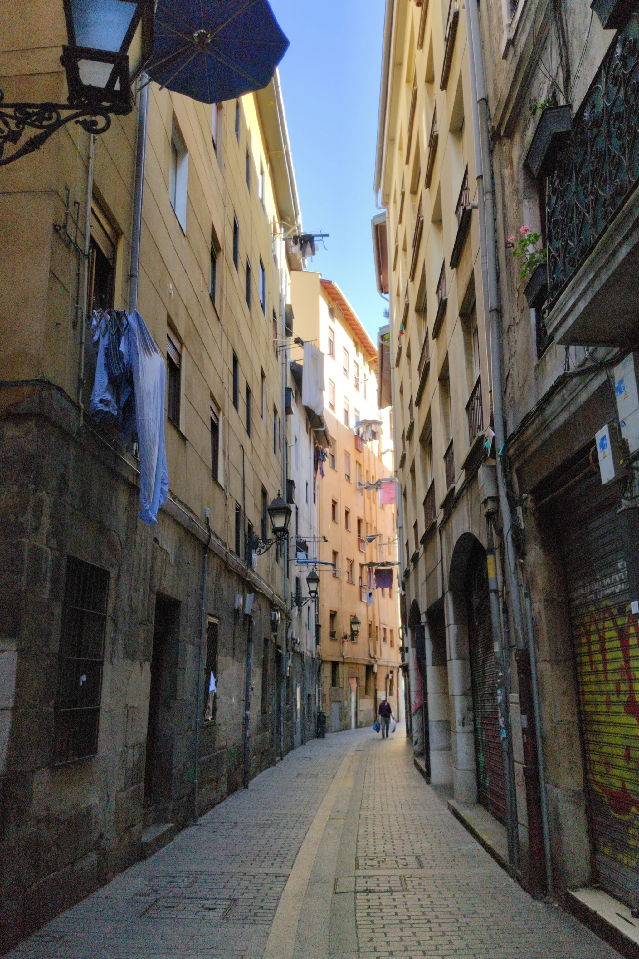 A narrow street with tall residential buildings on each side
