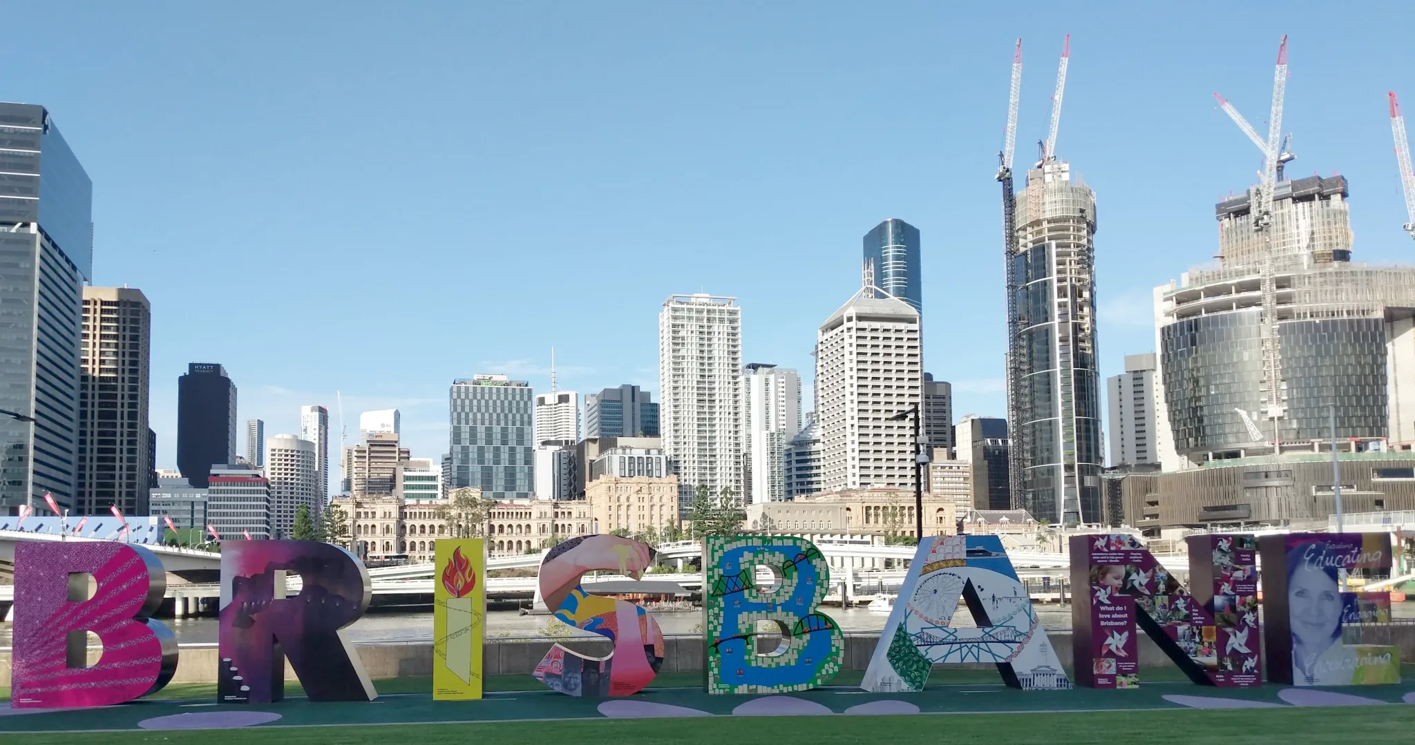 Human-sized free-standing letters
spell out BRISBANE by the river, Hollywood-style. These ones are decorated.
In the background, skyscrapers are visible on the far bank.
