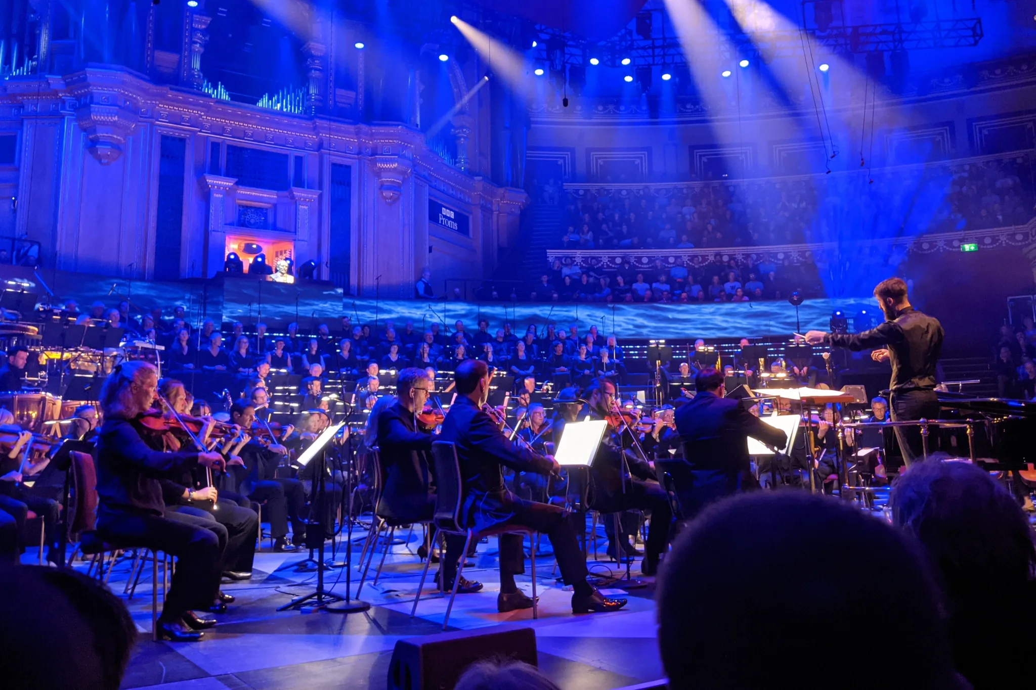 The stage at the Royal Albert Hall, with an orchestra and conductor and a
choir at the back.