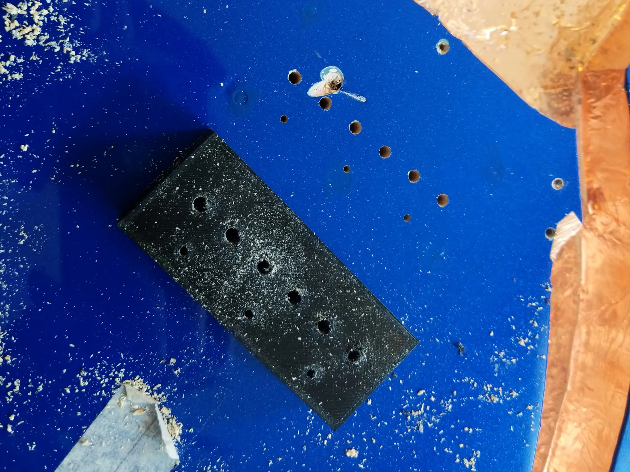 Nine straight holes in the top of the guitar, with a 3D-printed block next
to them. The block is about 15mm high and has the same pattern of holes