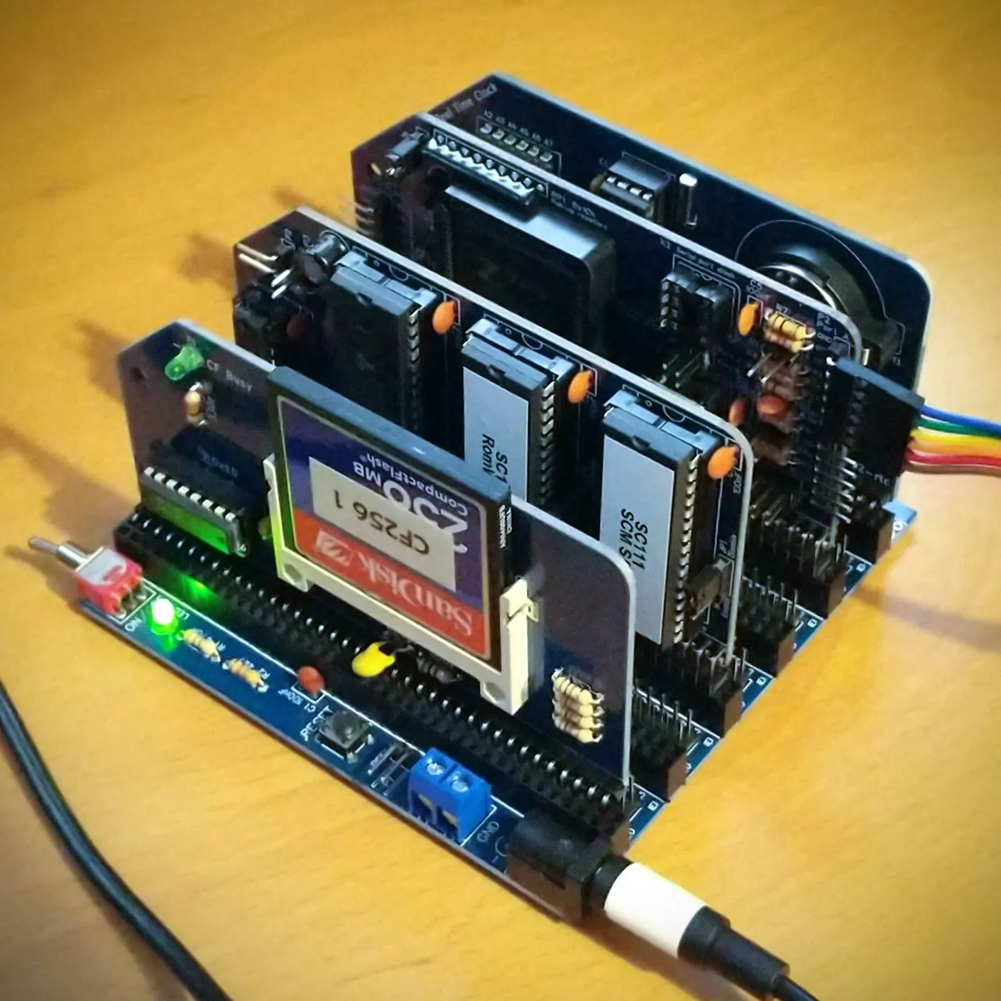 A small electronic device made up of a base board with multiple smaller
cards plugged into it, each with a few chips on. The whole thing fits into a 10
by 10 by 7 cm cuboid.