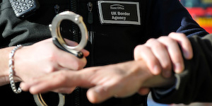 UKBA website image of a person being handcuffed